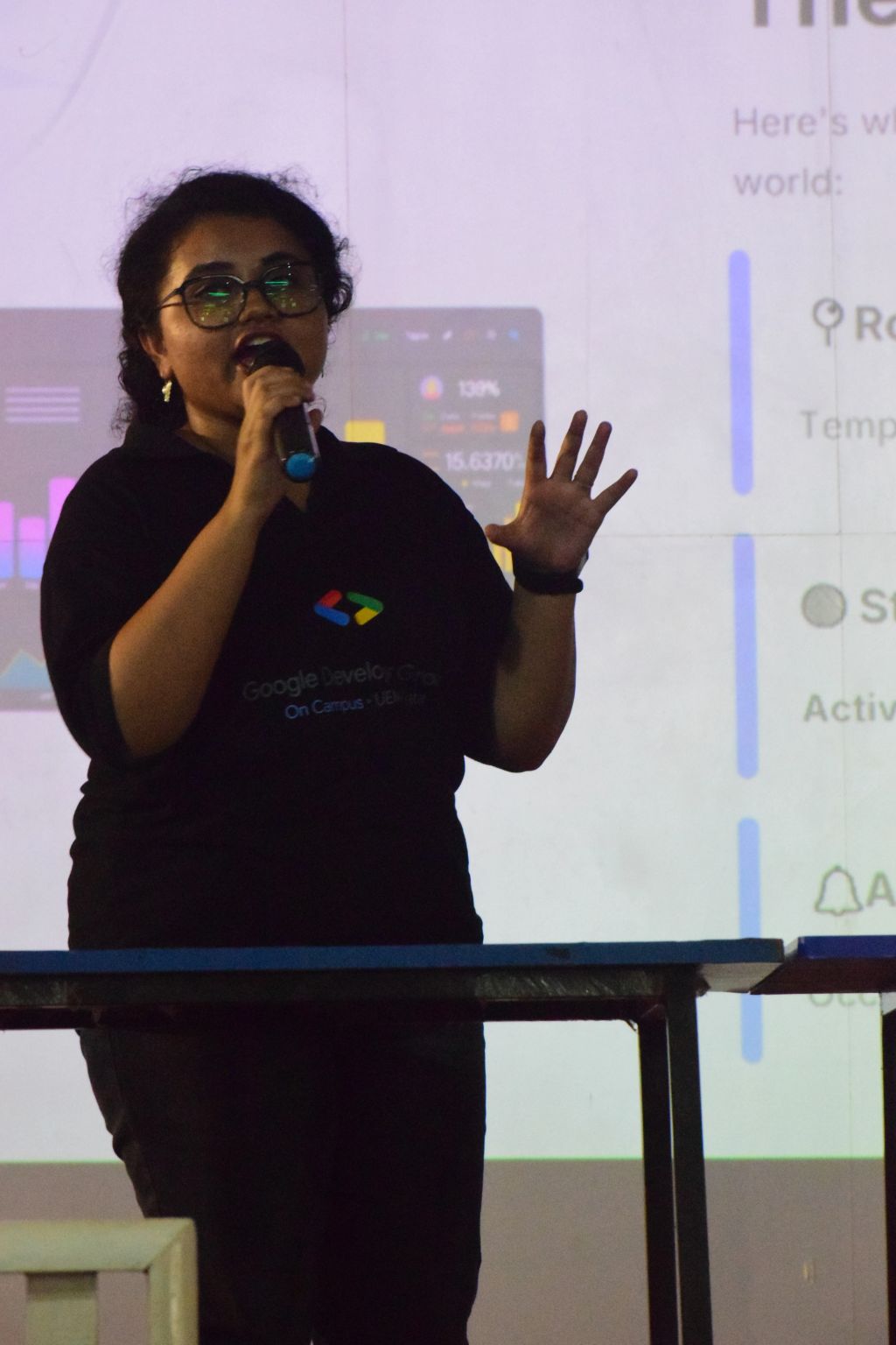 Soumika Das speaking with a microphone in a Google Developer Groups on Campus tee